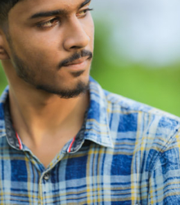 160664857-young-indian-man-showing-expression-over-nature-background